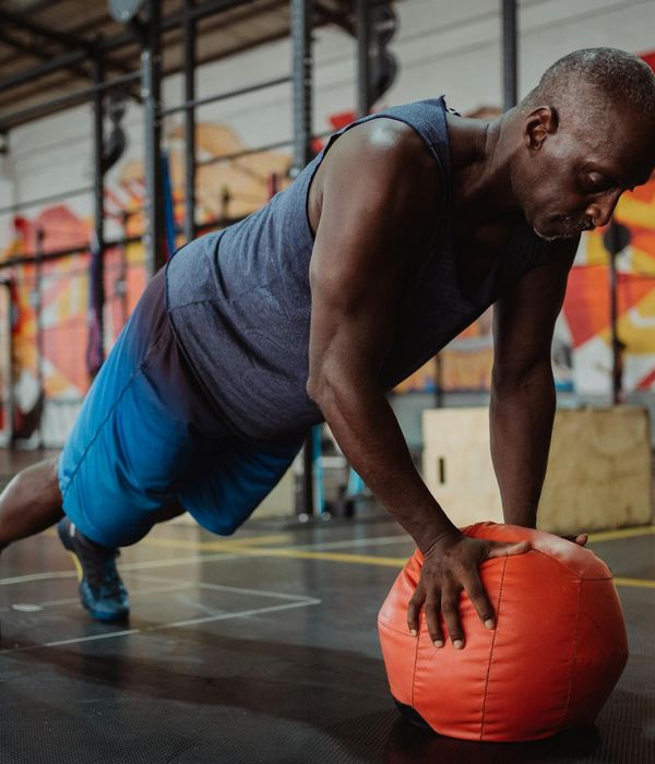 Man performing a core strength exercise in a modern gym setting.